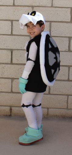 a young boy dressed up as a sailor with a hat and backpack on his back