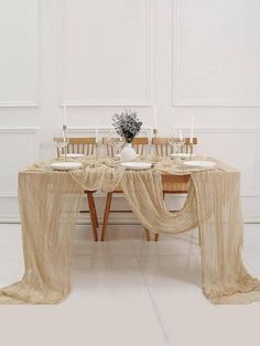 the table is set with white plates and place settings for four people to eat at