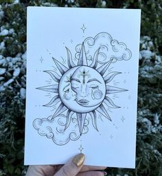 a person holding up a card with the sun and moon on it