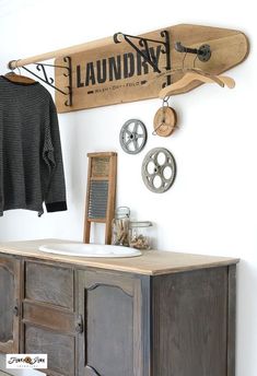 a bathroom with a sink, mirror and skateboard mounted to the wall above it