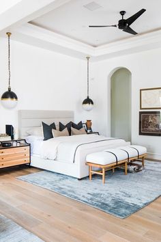 a bedroom with a bed, dresser and ceiling fan