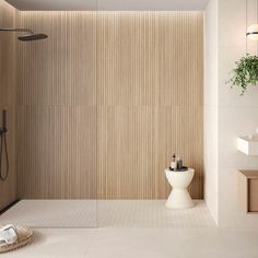 a white toilet sitting next to a shower in a bathroom under a wooden paneled wall