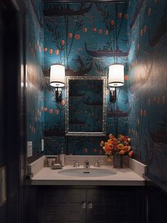 a bathroom with blue wallpaper and a white sink under a large mirror on the wall