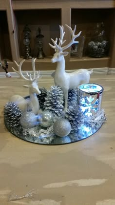 a glass plate topped with silver and white christmas decorations