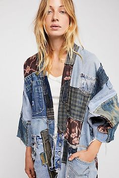 a woman wearing an oversize denim jacket with patches