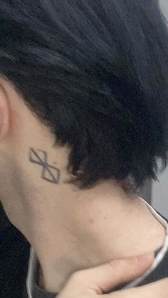 a woman with a small cross tattoo on her left side behind her ear and neck