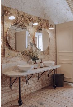 a bathroom with two sinks and mirrors on the wall