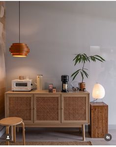 a living room with a table, chair and potted plant