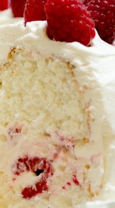 a piece of cake with white frosting and raspberries on top