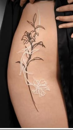 a woman's thigh with a flower tattoo on it