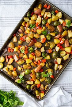 a pan filled with cooked vegetables on top of a white and blue towel next to lettuce