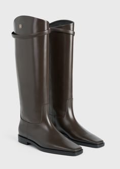 TOTEME's interpretation of classic riding boots have an understated, silver-tone metal monogram decorating the knee-high shaft. They're crafted in Italy from responsibly sourced leather with a pointed square toe, a decorative strap, and a low stacked heel measuring 22mm. Keep them in focus by wearing them with leggings or tucked-in pants. Classic Knee-high Boots For Business, Luxury Brown Knee-high Boots For Business, Sweater Blazer, Riding Boot, In Focus, Leather Riding Boots, Clutch Pouch, Swim Shop, Stacked Heel