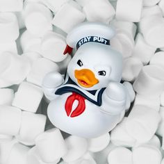 a rubber duck floating on top of marshmallows in the shape of a sailor's hat