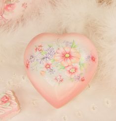 a pink heart shaped box with flowers painted on it