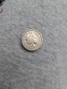 a coin sitting on top of a gray shirt