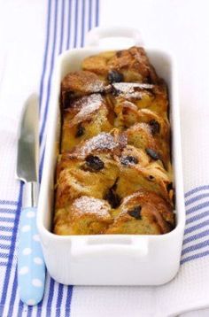 a casserole dish with blueberries and powdered sugar in it on a table