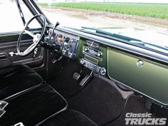 the interior of an old classic car with black leather seats and dash board, along with steering wheel controls