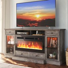 a flat screen tv sitting on top of a wooden entertainment center next to a fire place