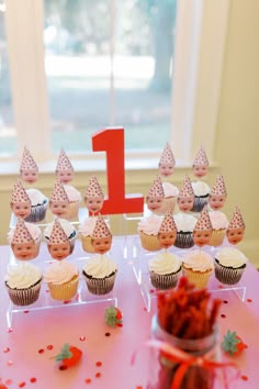 cupcakes are on a pink table with white frosting