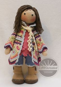 a crocheted doll wearing a jacket and boots