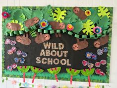 a bulletin board that says wild about school with paper flowers and leaves on the bottom