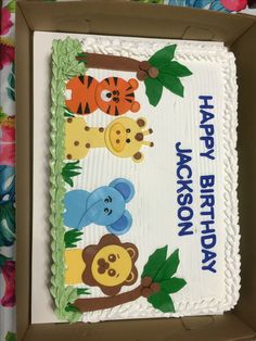 a birthday cake decorated with animals and leaves