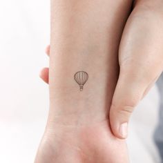 a small hot air balloon tattoo on the wrist