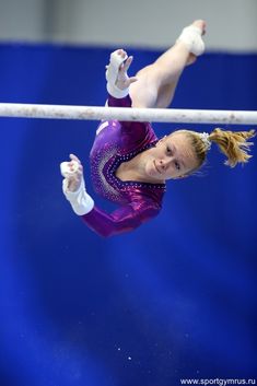 a woman is performing on the uneven bars