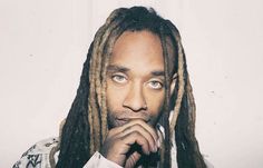 a man with dreadlocks is looking at the camera