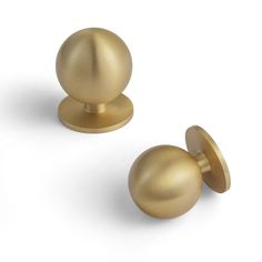 two brass colored knobs on white background