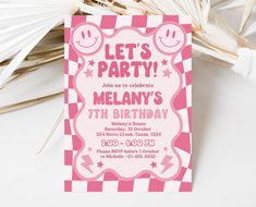 a pink and white checkered birthday party card with smiley faces on it, sitting next to palm leaves