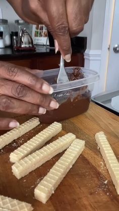 a person cutting up food on top of a wooden table