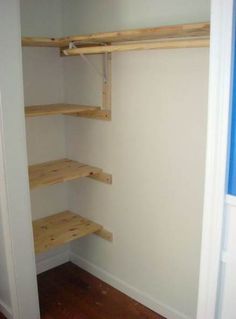 an empty closet with wooden shelves in it