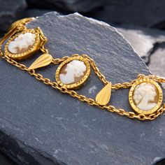 This elegant bracelet features seven oval shell cameos bezel-set along chain and teardrop shaped gold tablets to create an undulating effect. The bracelet has French hallmarks on the slide-in clasp. The bracelet is crafted in 18k yellow gold and fits up to a 7 inch wrist. Elegant Cameo Bracelet For Formal Occasions, Elegant Yellow Gold Bracelet With Intaglio, Elegant Gold Bracelets With Cabochon, Elegant Gold Bracelet With Cabochon, Elegant Yellow Gold Bracelets With Intaglio, Elegant Yellow Gold Intaglio Bracelets, Elegant Cameo Bracelet Jewelry, Elegant Yellow Gold Intaglio Bracelet, Elegant Gold Intaglio Bracelet