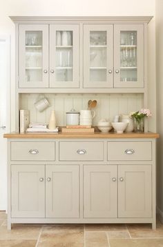 a kitchen with white cabinets and wooden counter tops