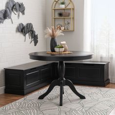 a black table sitting on top of a wooden floor next to a white and green rug