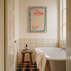 a white bath tub sitting next to a wooden stool under a painting on the wall