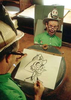 a man sitting at a table with a drawing on it