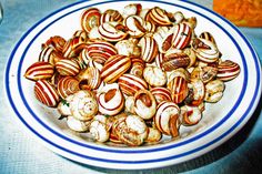 a white plate topped with lots of nuts on top of a blue and white table