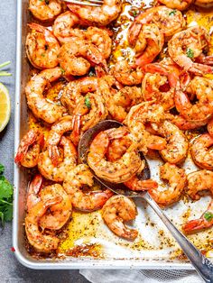 a pan filled with cooked shrimp and garnished with parsley on the side