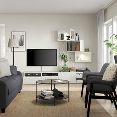 a living room filled with furniture and a flat screen tv mounted on a wall above a coffee table