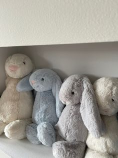 several stuffed animals are lined up in a row on the shelf next to each other