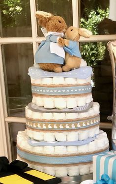 a teddy bear sitting on top of a stack of diapers next to a window