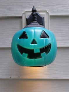 a blue jack - o - lantern hanging from the side of a house with a light on