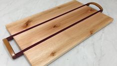 a cutting board with two wooden handles on it