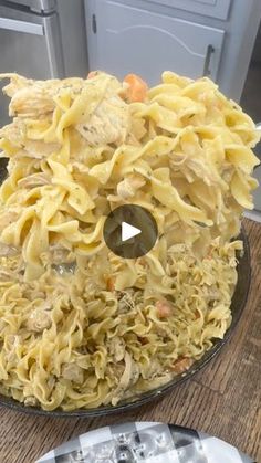 a bowl filled with pasta and meat on top of a wooden table