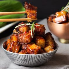 some food is in a bowl with chopsticks sticking out of it and on the table