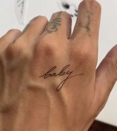 a person's hand with the word baby tattooed on it