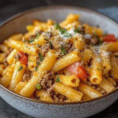 a bowl filled with pasta and meat on top of a table