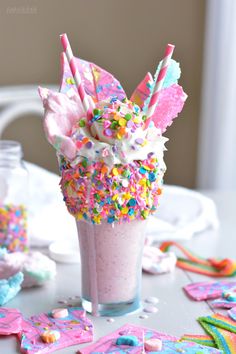 a pink drink with sprinkles and candy on top